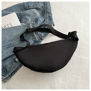 Minimalist black nylon sports waist bag detail shown with denim jacket and arts book
