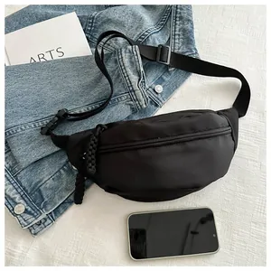 Close-up of a black nylon minimalist waist bag with a textured fabric background