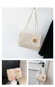 Detalle de bolso bandolera de paja tejida beige con adorno floral y correas de cuerda