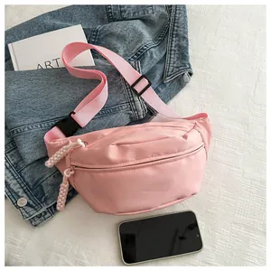 Close-up of minimalist pink nylon fanny pack with stylish braided zipper pulls