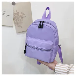 Detailed shot of a small purple nylon backpack for women showing front zipper pocket