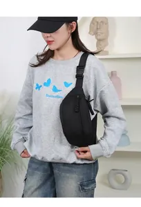 Detailaufnahme einer schwarzen Nylon-Brusttasche, getragen von einem Modell im Alltag