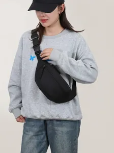Minimalistische schwarze Brusttasche aus Nylon, getragen von einem Model im Alltag