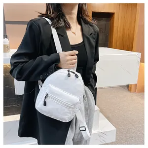 Detailed view of a stylish white nylon mini backpack for women in a lifestyle setting
