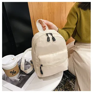 Cream nylon mini backpack shown in a modern lifestyle setting with a soft warm aesthetic