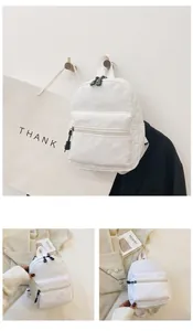 Three-view display of a minimalist white nylon women's backpack for students.