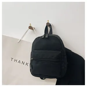 Close-up of a stylish black nylon backpack hanging on a wall hook