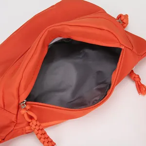 Detailansicht der hellorangen Nylon-Gürteltasche mit grauem Innenfutter und Reißverschluss