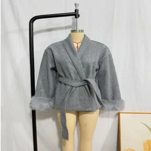 Close-up of elegant grey wool coat sleeves with luxurious grey faux fur cuff detailing