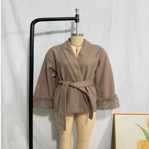 Elegant camel wool coat with faux fur cuffs and waist tie on mannequin.