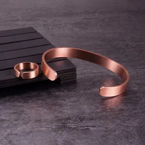 Vista detallada del brazalete de cobre rojo mate y el conjunto de anillo ajustable