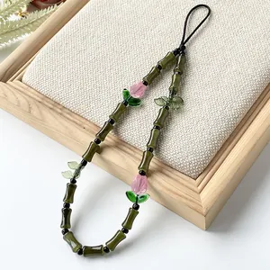 Detalle de una correa para móvil hecha a mano de bambú de cristal verde y tulipanes
