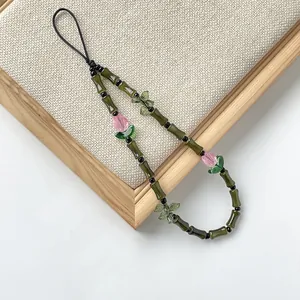 Primer plano de un colgante de cristal para móvil con bambú y tulipanes rosas!!