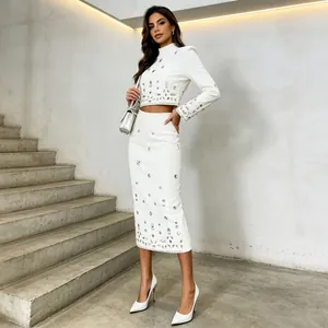 Detailansicht eines weißen Sets mit Strasssteinen, bauchfreiem Top und Midirock