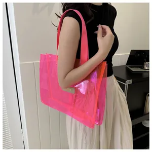 Grand sac cabas transparent rose néon porté par un mannequin dans un décor d'intérieur.