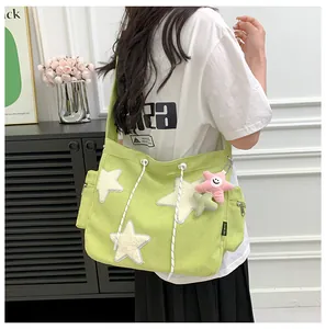 Fashionable light green corduroy tote bag with plush star patches worn by a model.