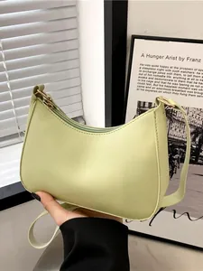 Minimalistische hellgrüne halbmondförmige Schultertasche mit goldenen Metallelementen