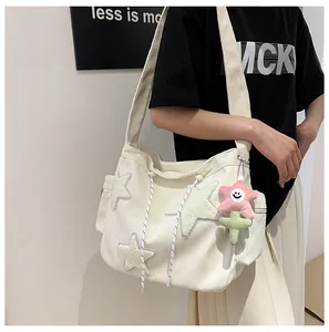 Détail d'un sac cabas en velours blanc avec des patchs d'étoiles et un porte-clés mignon