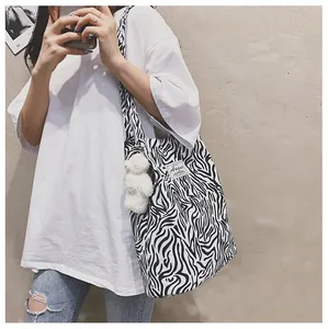 Gros plan d'un sac cabas en toile à motif zèbre avec un joli pendentif ours blanc
