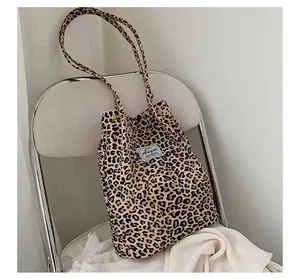 Gros plan d'un sac cabas imprimé léopard suspendu à une chaise, montrant la texture.