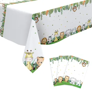 Detail view of jungle wild animal tablecloth and matching cards for birthday party decor.