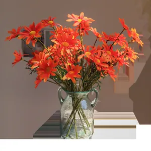 Lebhafte künstliche orangefarbene Kamillen-Gänseblümchen-Seidenblumen in Glasvase für Heimdeko