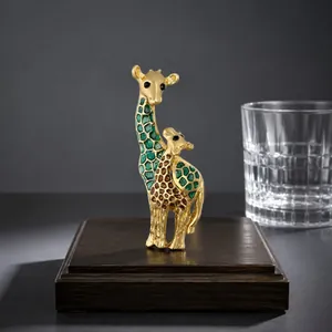 High-detail close-up of an elegant giraffe brooch with green enamel and a shiny gold finish