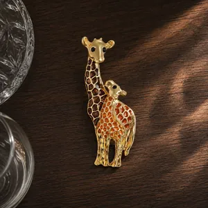 Close-up of elegant gold enamel giraffe brooch with brown and orange patterns