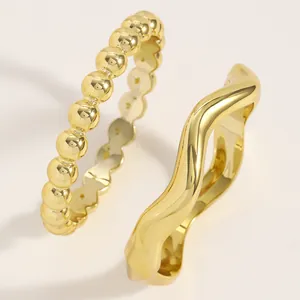 Close-up detail of gold-finished irregular wavy and beaded punk style bangle set