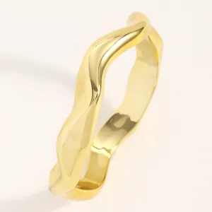 Close-up of gold irregular wavy bracelet with polished finish and punk style