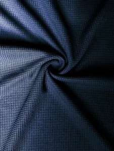 Macro view of navy blue waffle knit fabric texture showing the detailed weave pattern