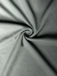 Close-up of premium grey waffle knit fabric showing detailed grid texture and soft drape.