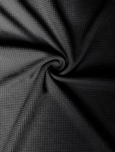 Detailed close-up of high-quality black waffle knit fabric texture for men's slim t-shirt