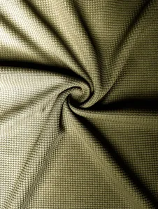 Close-up of olive green waffle knit fabric showing detailed texture and spiral fold