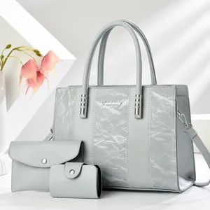 Vista dettagliata del set di 3 borse grigie con una borsa tote dalla texture stropicciata.