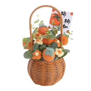 Ramo de flores tejidas a mano en una cesta con lindos caquis de ganchillo para regalo