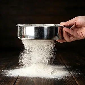 Professionelles Mehlsieb aus Edelstahl beim Sieben auf einem Holztisch gezeigt