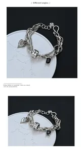 Viste macro dettagliate di un bracciale hip-hop retrò con ciondoli a croce e zircone nero.