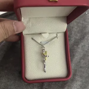 Close-up of creative gold and silver hugging couple pendant necklace in a red gift box