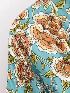 Nahaufnahme des lebendigen Blumendrucks auf dem weichen Stoff des Kimono-Cardigans