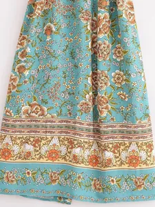 Nahaufnahme des böhmischen Blumen- und Einhorndrucks am Saum des blauen Viskose-Kimonos