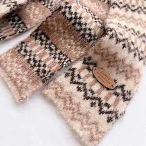 Gebreide wollen sjaal met zigzagpatroon en decoratief leren label voor de winter