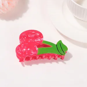 Detalle macro de una pinza para el pelo con forma de cereza rosa y hoja verde realista
