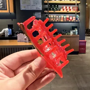 Primer plano de una pinza para el pelo roja con motivo de fruta en un ambiente de café