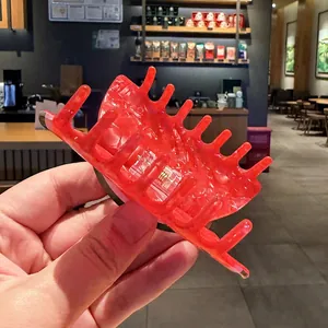 Detalle en primer plano de pinza de pelo roja con diseño fruta y textura traslúcida