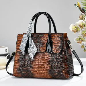 Sac à main marron à motif crocodile avec poignées noires et détail écharpe en soie