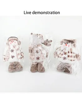 Détail de trois peluches de bonhomme de neige et renne de Noël sous emballage
