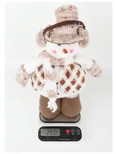 Poupée en peluche bonhomme de neige de Noël pesée sur une balance électronique