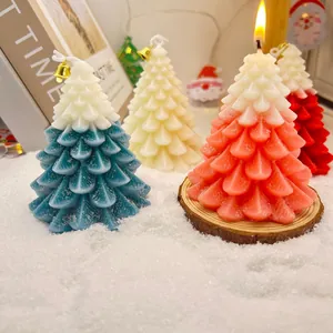 Vue détaillée de bougies parfumées colorées en forme de sapin de Noël sous la neige