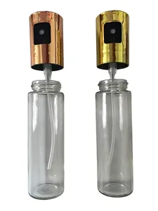 Dual glass oil sprayers with gold and rose gold caps for kitchen and BBQ.